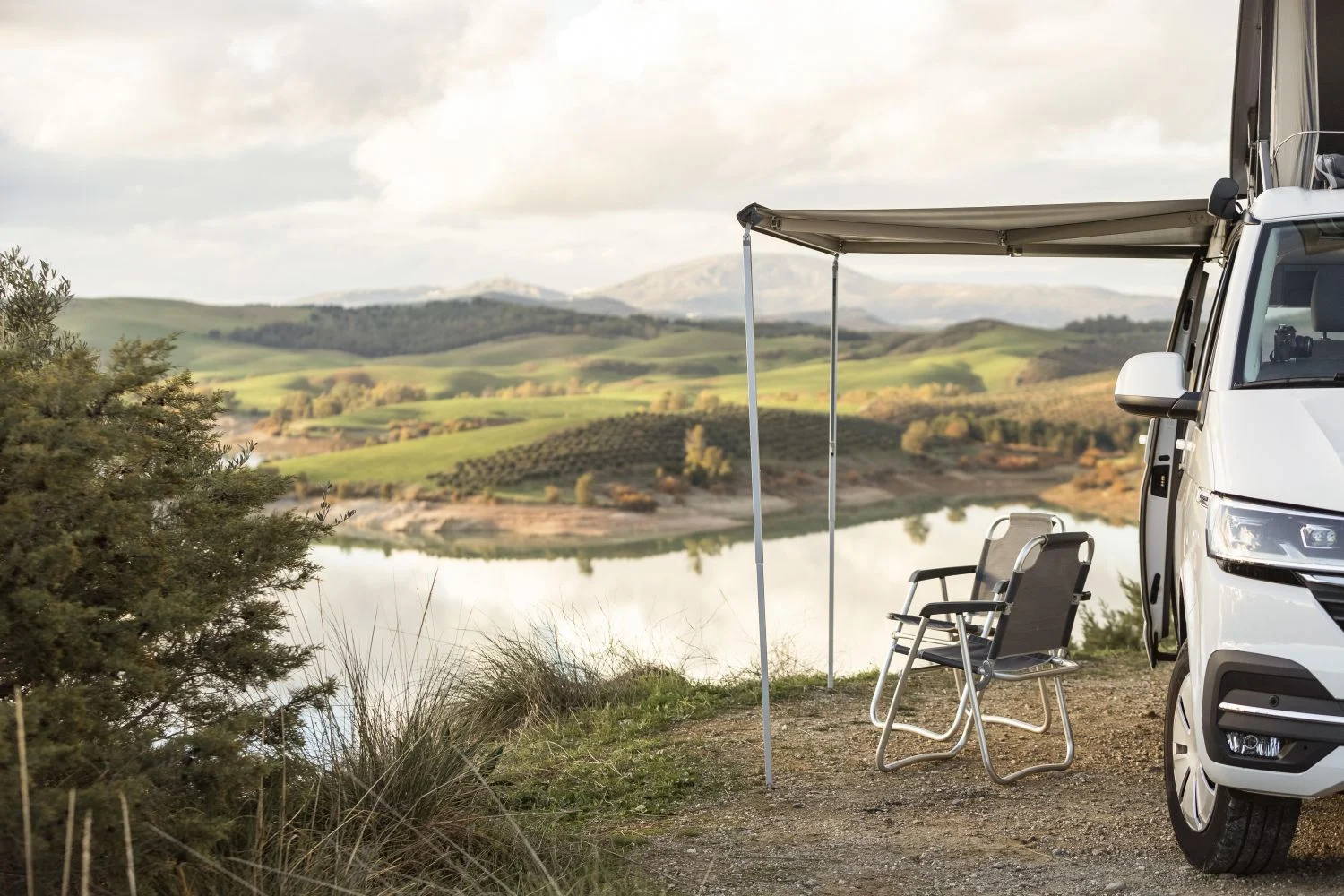 Family car with a rooftop tent set up in a scenic natural environment, ideal for camping and outdoor adventures.
